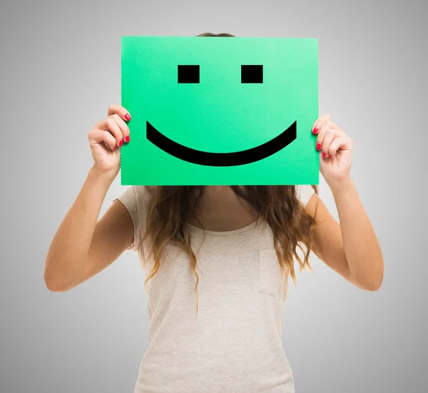 Mujer sosteniendo un emoticono sonriente — Foto de Stock