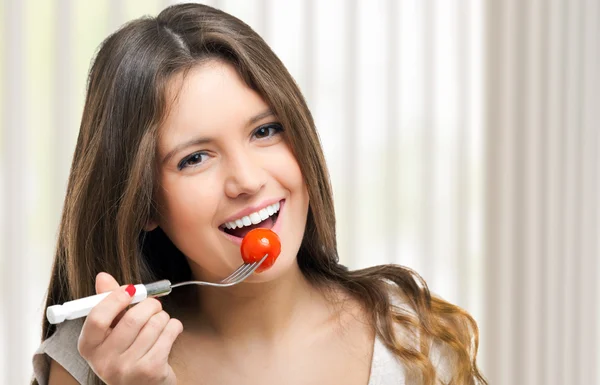 Frau isst eine Tomate — Stockfoto