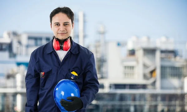 Werknemer tegenover een fabriek — Stockfoto