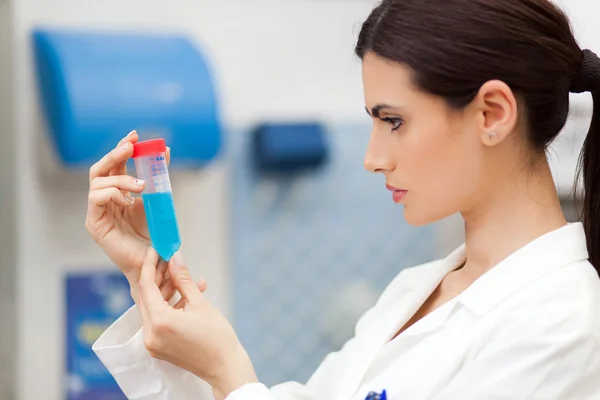 Cientista olhando para um tubo de ensaio em um laboratório químico — Fotografia de Stock