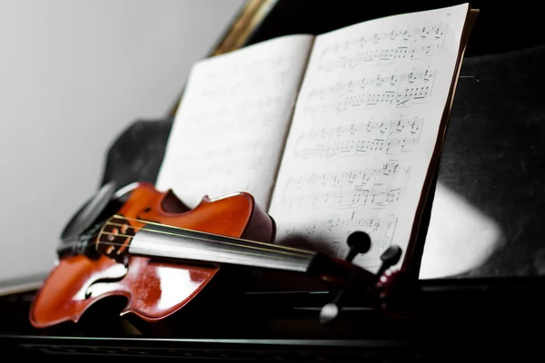Geige auf einem Klavier liegend — Stockfoto