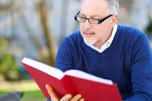 Homme mûr lisant un livre — Photo