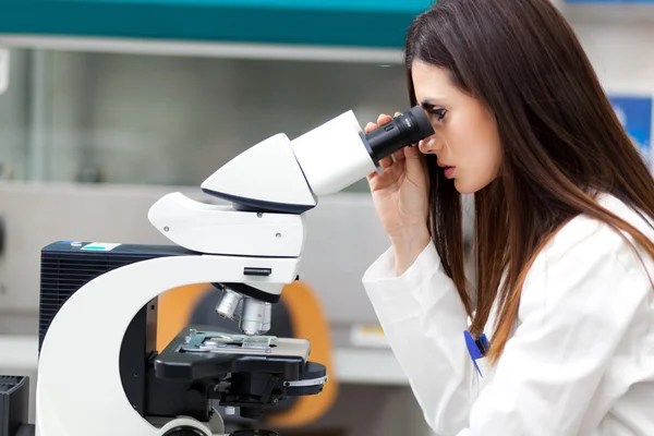 Científico mirando a través del microscopio — Foto de Stock