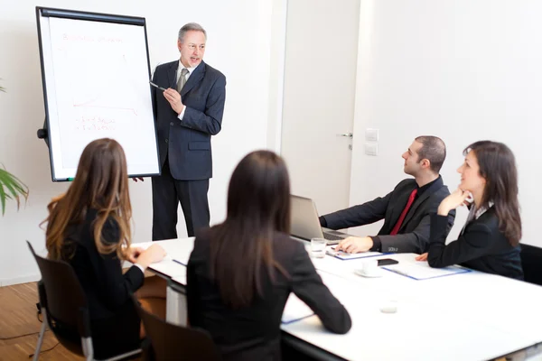 Homme d'affaires pointant vers le tableau blanc lors d'une réunion — Photo