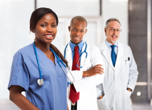 Enfermera sonriente frente a su equipo médico —  Fotos de Stock