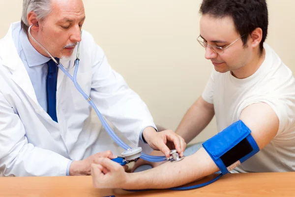 Médico verificando a pressão arterial — Fotografia de Stock