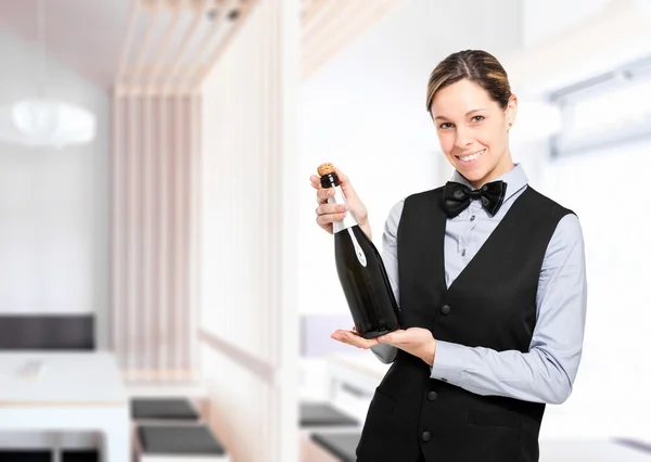 Waitress holding a bottle of champagne — Stock Photo, Image