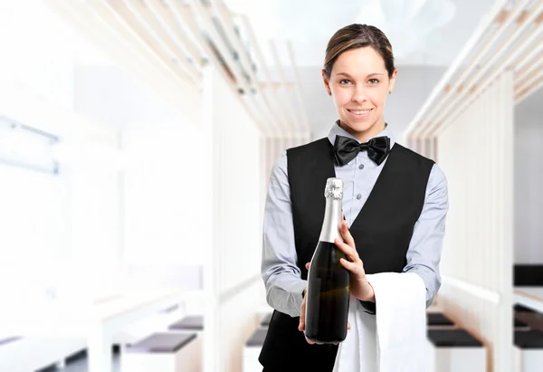 Kelnerka, trzymając butelkę szampana — Zdjęcie stockowe