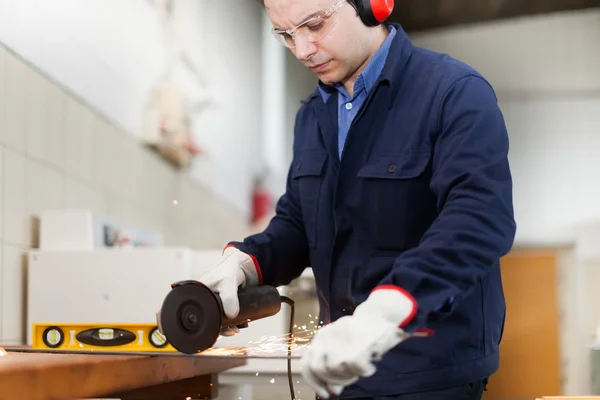 Trabajador usando una amoladora — Foto de Stock