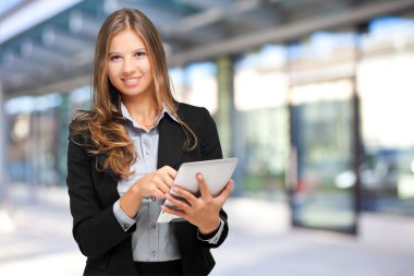 Tablet kullanan genç bir kadın.