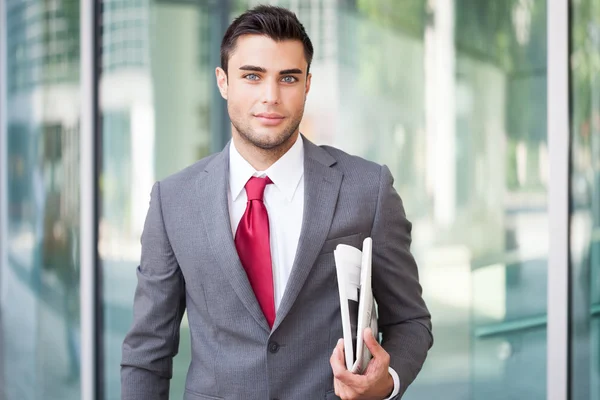 Hombre de negocios sosteniendo un periódico — Foto de Stock