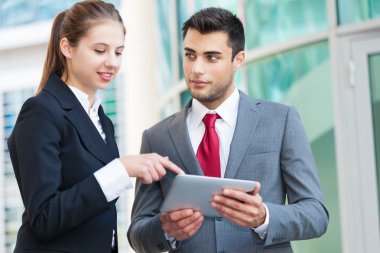 bir tablet üzerinde çalışan iş adamları