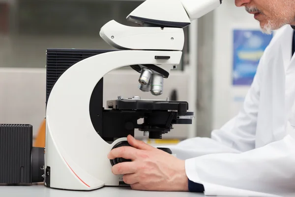 Homem usando um microscópio em laboratório — Fotografia de Stock