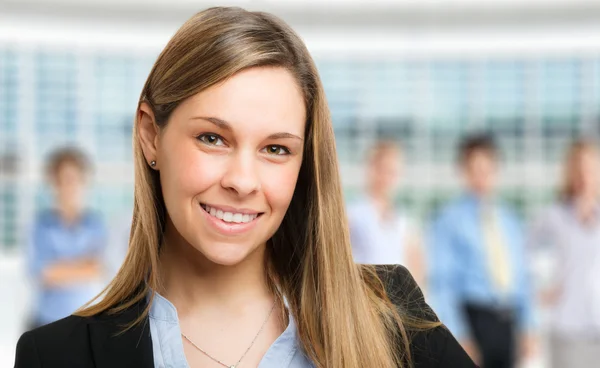 Business woman with staff in background — Stock Photo, Image