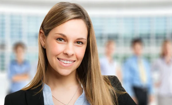 Mujer de negocios con personal en segundo plano — Foto de Stock