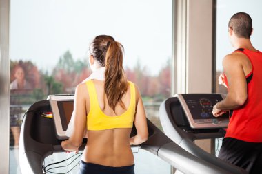 İnsanlar koşu bandında antrenman yapıyor