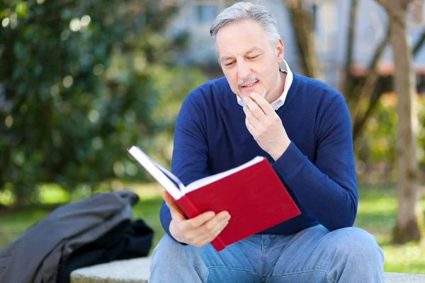 Homme mûr lisant un livre — Photo