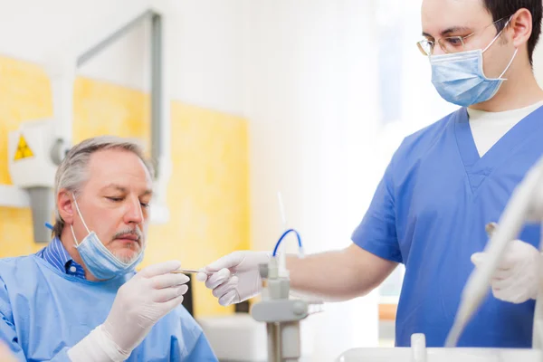 Assistente dando ferramentas para um dentista — Fotografia de Stock