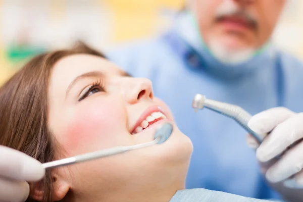 Dentista cura una paziente donna — Foto Stock