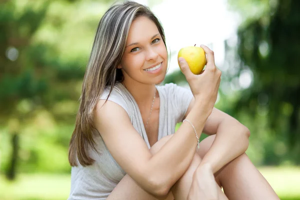 Vrouw die een appel eet — Stockfoto