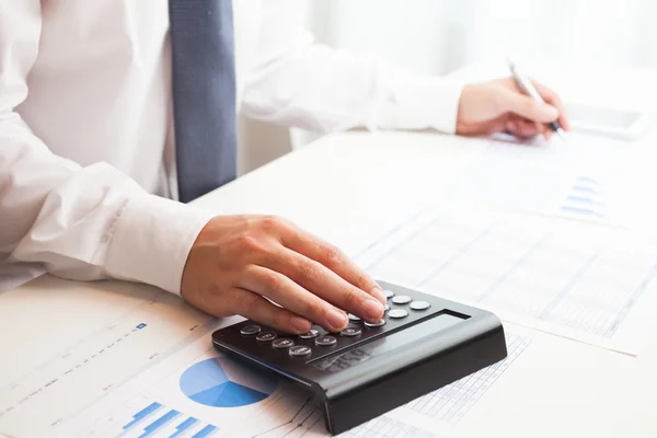 Businessman checking numbers on a document Stock Image