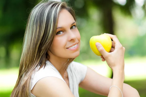 Kvinna äta ett äpple i parken — Stockfoto