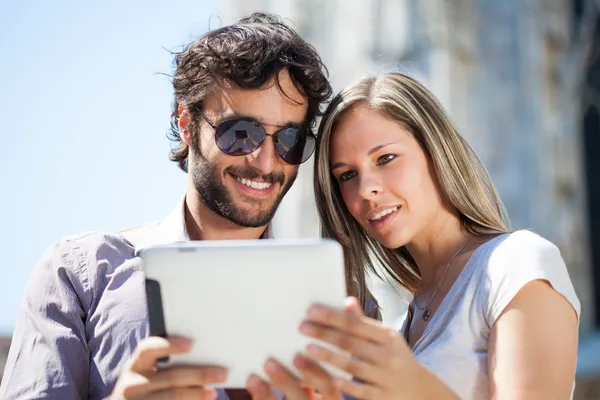 Couple using tablet outdoors — Stock Photo, Image