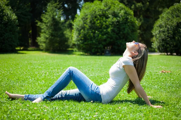 Kvinde sidder på græsset - Stock-foto
