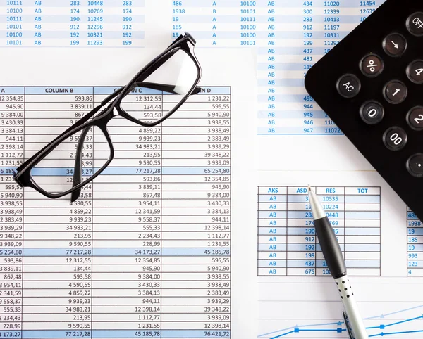 Calculator, eyeglasses and financial charts — Stock Photo, Image