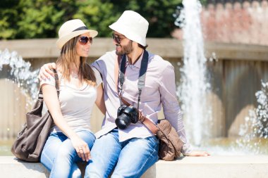 Çeşme yanında oturan turist