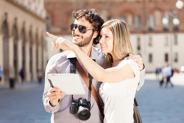 Turistas casal segurando tablet — Fotografia de Stock