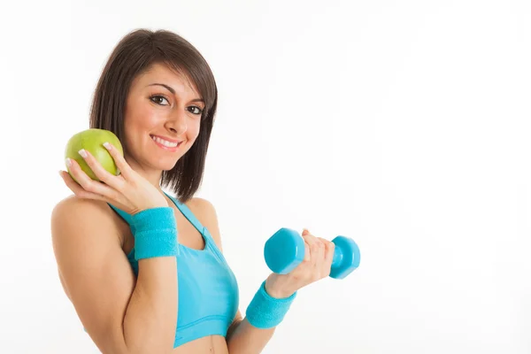 Mujer sosteniendo una manzana y una mancuerna — Foto de Stock