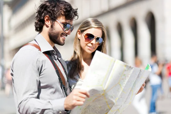 Couple of tourists holding map — Stock Photo, Image