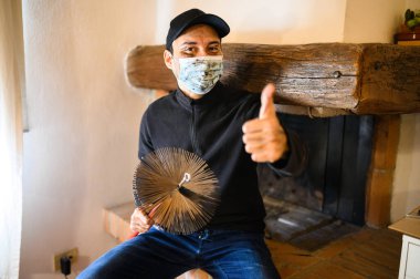 Genç baca temizleme portresi Coronavirus acil durumu nedeniyle maske takıyor.