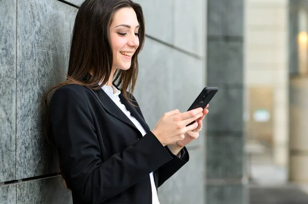 美しい若い女性マネージャー彼女のスマートフォン屋外を使用して — ストック写真