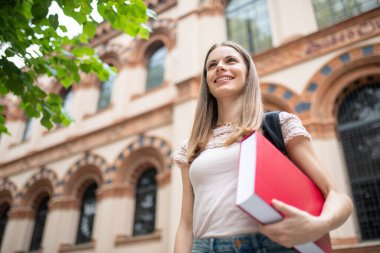 Üniversite önünde gülümseyen bir öğrencinin portresi