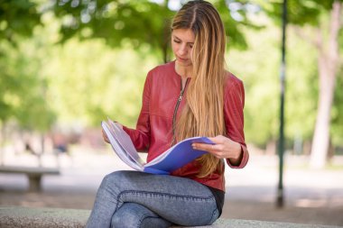 Parkta okuyan genç bir kadın.