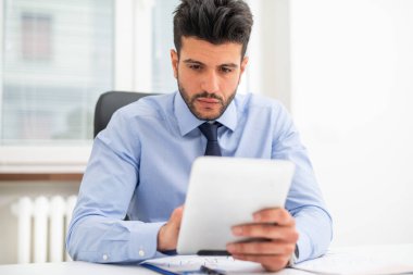 Ofisinde tablet kullanan bir iş adamının portresi