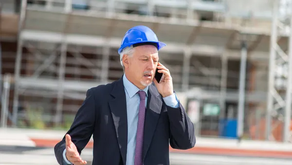 건축가 관리자가 앞에서 핸드폰으로 얘기하는 — 스톡 사진