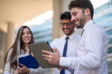 Ofislerinde tablet kullanan bir grup iş adamı, takım çalışması konsepti