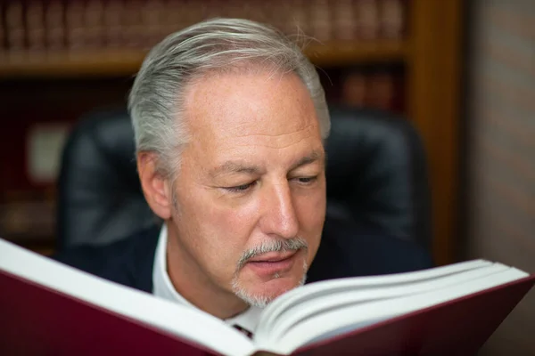 Senior Geschäftsmann Liest Ein Buch Seiner Bibliothek — Stockfoto