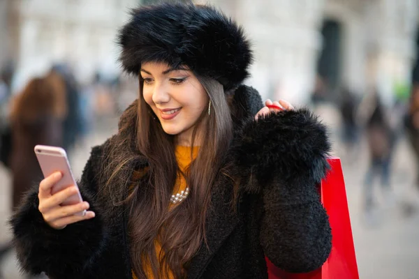 Kadın Kışın Alışveriş Yaparken Cep Telefonunu Kullanıyor — Stok fotoğraf