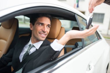 Tamirden sonra yeni araba anahtarını alan adam.