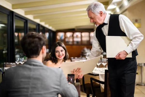 Číšník Dává Menu Páru Elegantní Restauraci — Stock fotografie