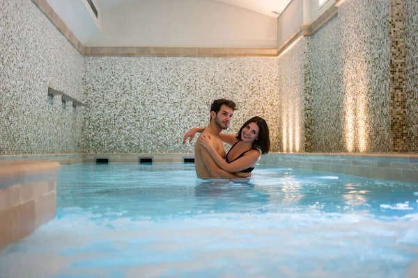 年轻夫妇在室内游泳池里玩得很开心 — 图库照片