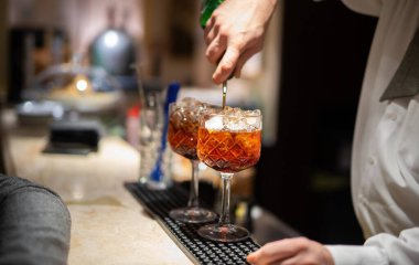 Barmen iki kokteyl hazırlıyor.