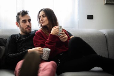 Kanepede kahve içen genç bir çift.