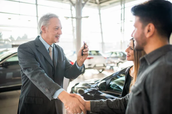 汽车经销商进行握手 并提供钥匙以完成新车的交易 — 图库照片