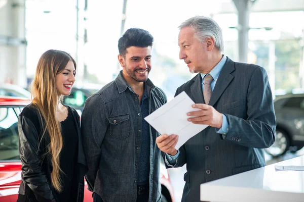 Feliz Joven Familia Hablando Con Vendedor Elección Nuevo Coche Una — Foto de Stock