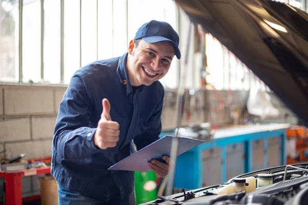 Uśmiechnięty Mechanik Podnoszący Kciuki Przed Samochód Otwartym Kapturem — Zdjęcie stockowe